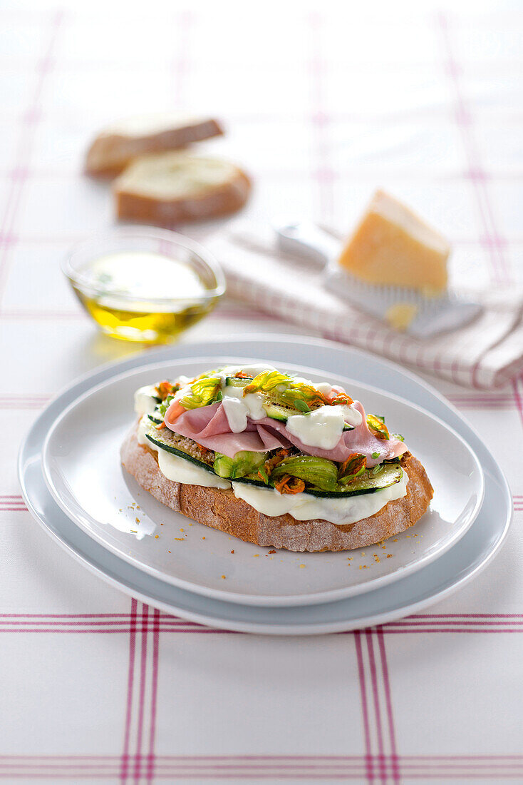 Geröstetes Brot mit Zucchiniblüten, Mozzarella und Schinken