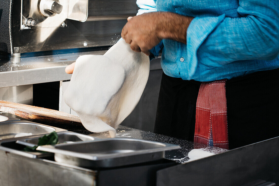 Pizza maker moulding pizza dough