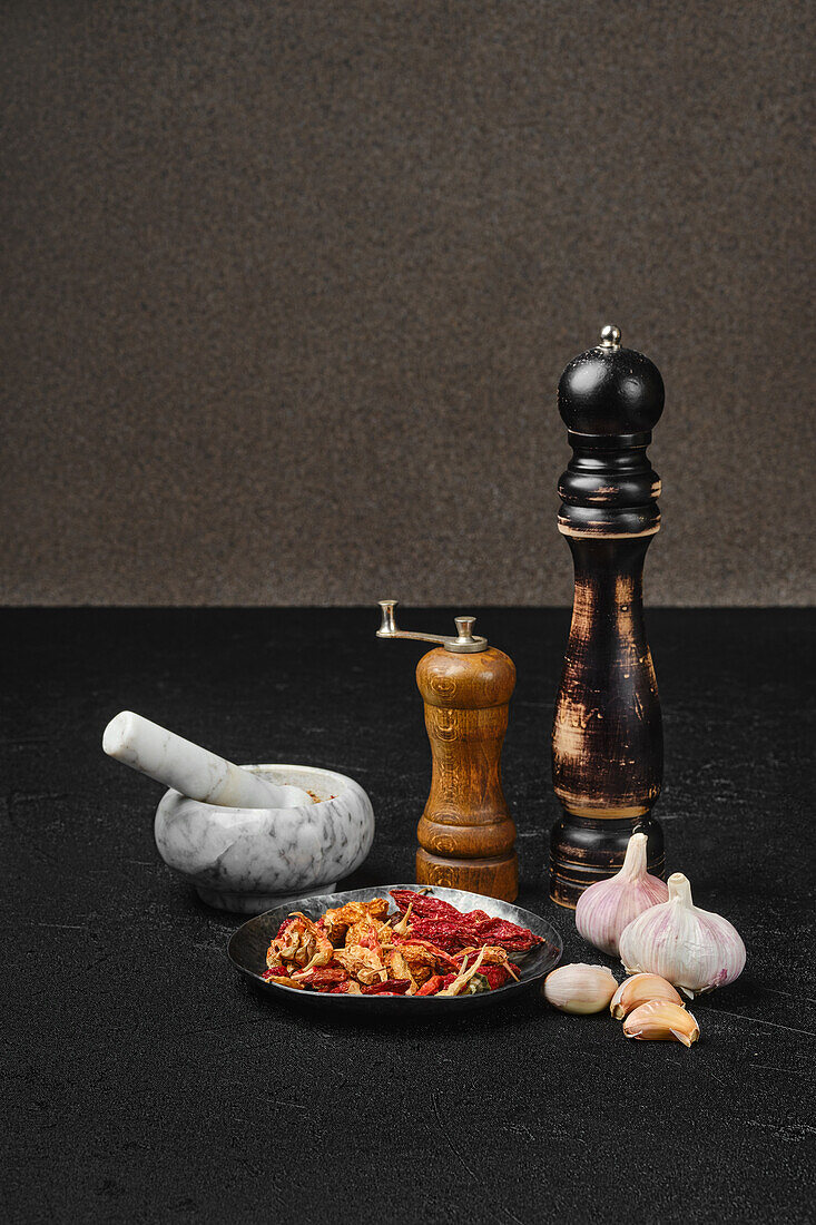 Mortars and spice grinders alongside garlic and dried chilli peppers