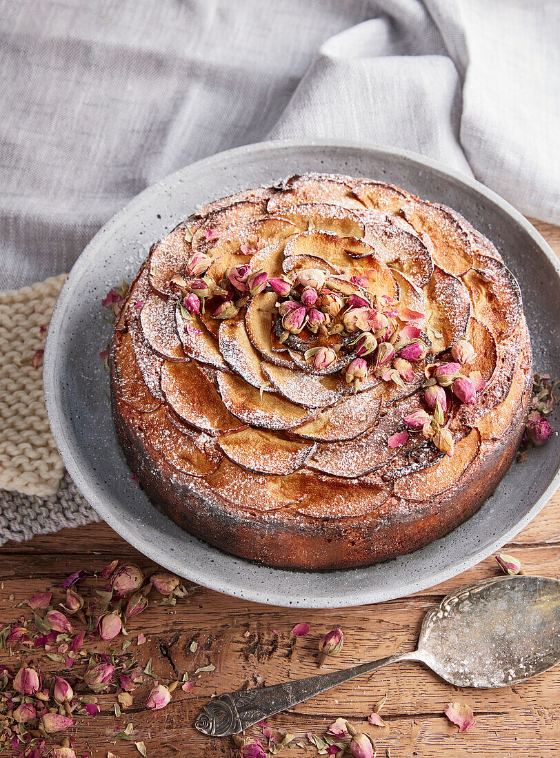 Apfelkuchen mit Rosenblüten und Puderzucker