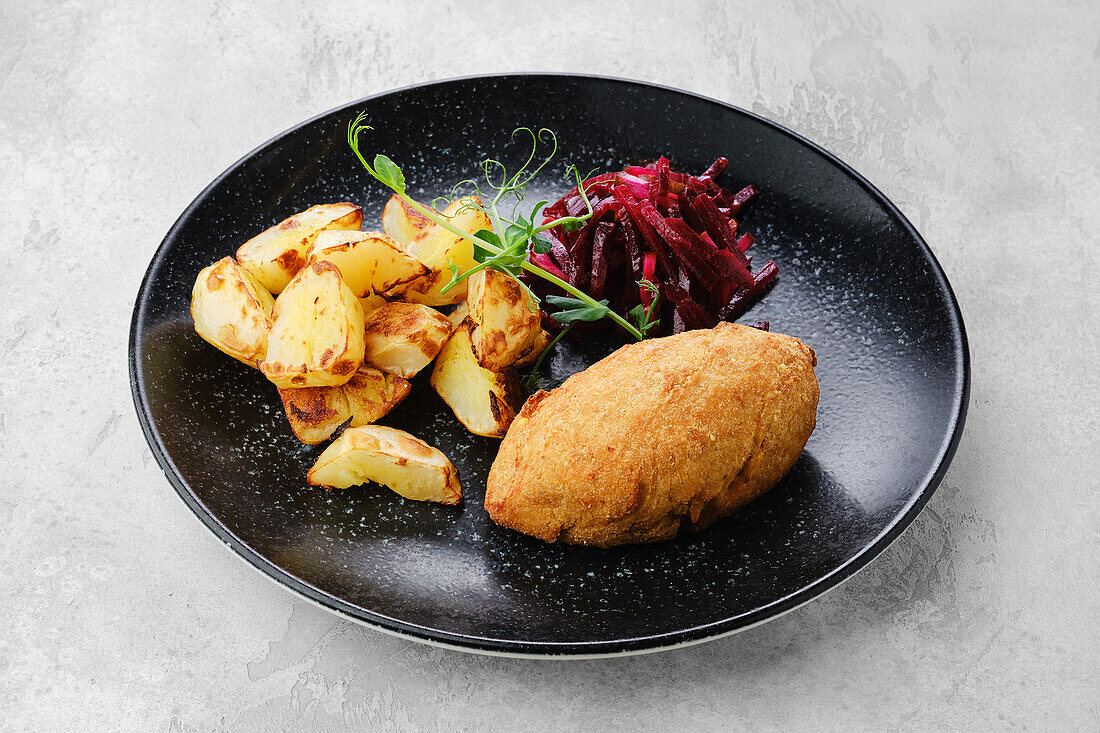 Kiev cutlet with roast potatoes and beetroot salad