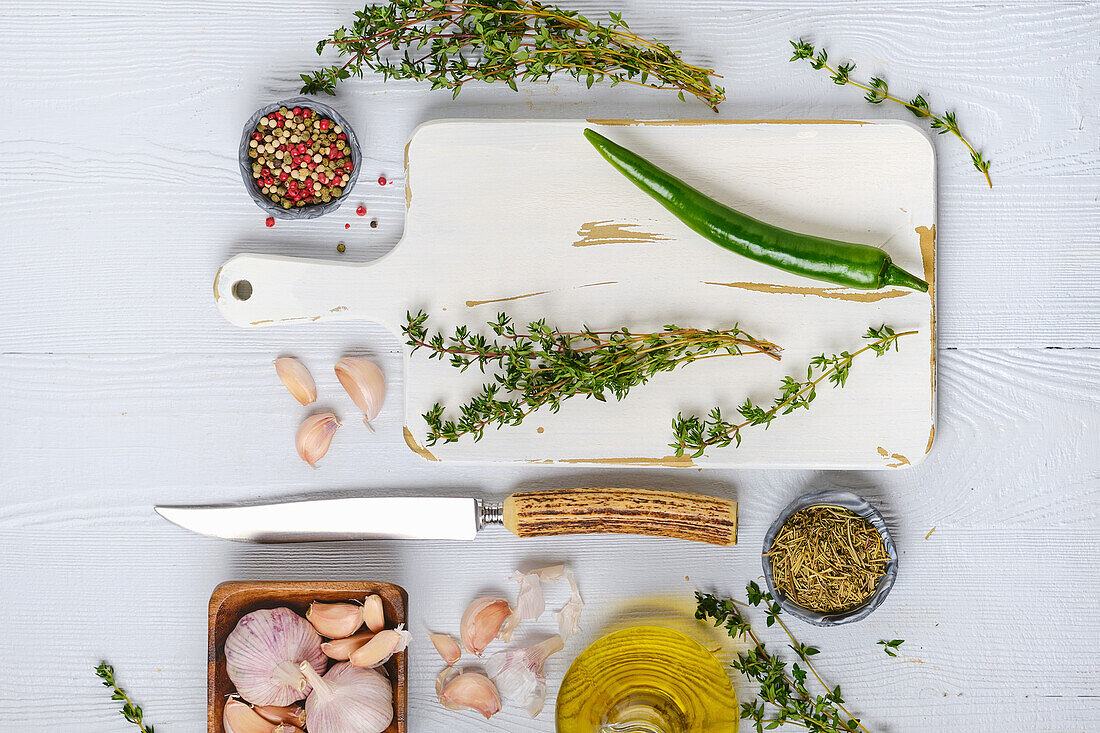 Schneidebrett mit frischem Thymian, Gewürzen und Öl für Würzmarinade