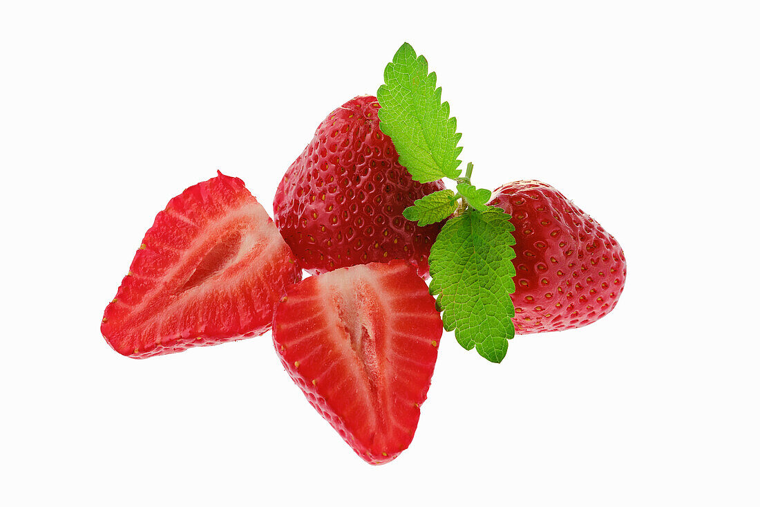 Ganze und aufgeschnittene Erdbeeren mit Minzblatt