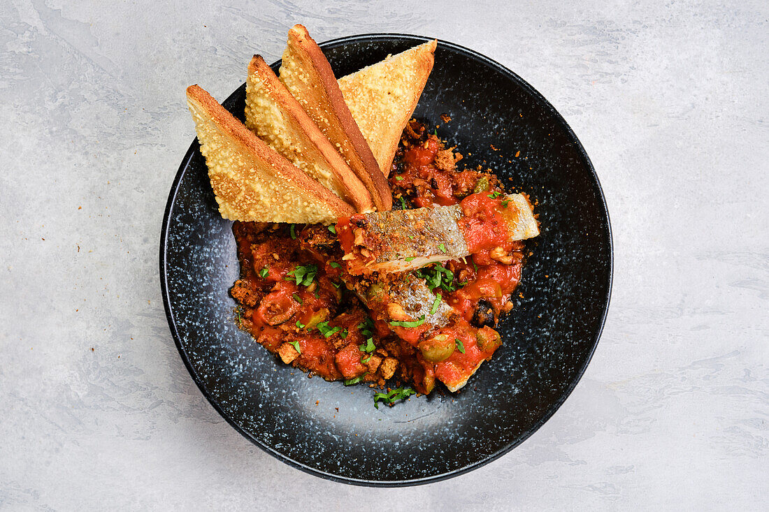 Gebratenes Zanderfilet mit Tomaten-Oliven-Sauce und Toastbrot