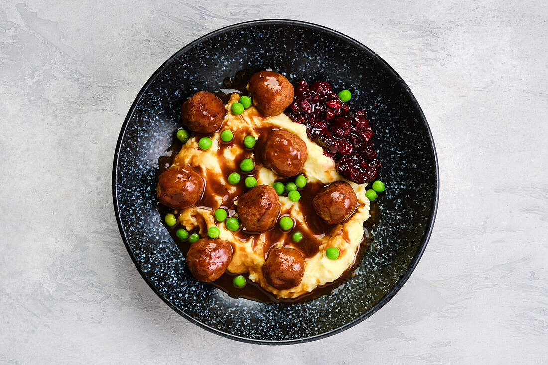 Fleischbällchen in Soße mit Kartoffelpüree, Erbsen und Preiselbeeren