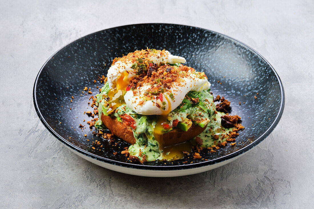 Poached egg on an avocado roll with bacon crumbs