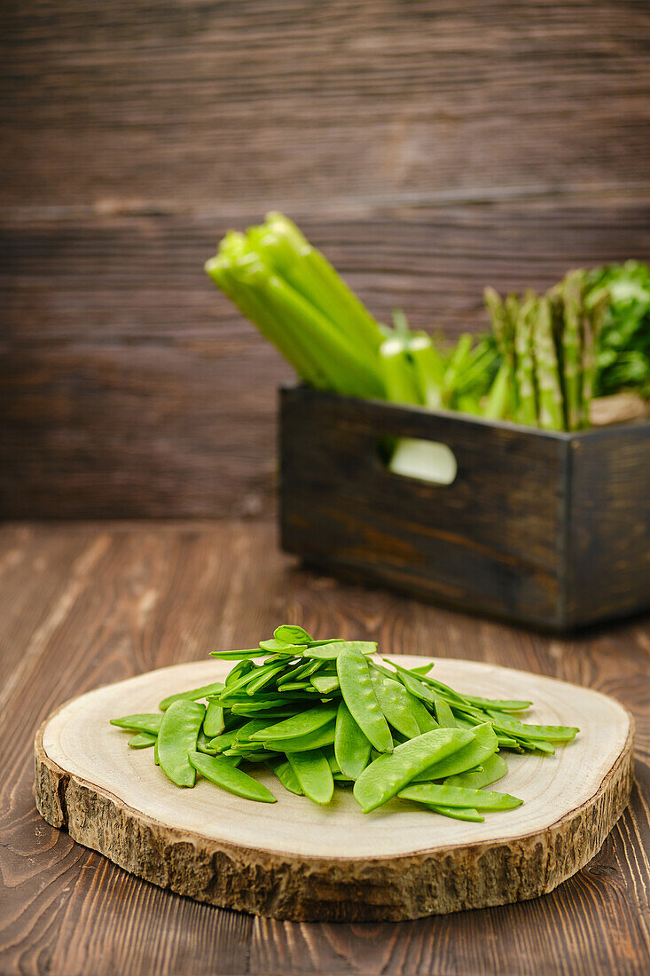 Fresh mangetout on wooden chopping board