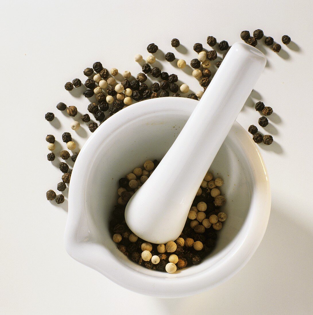 Black and white peppercorns in mortar