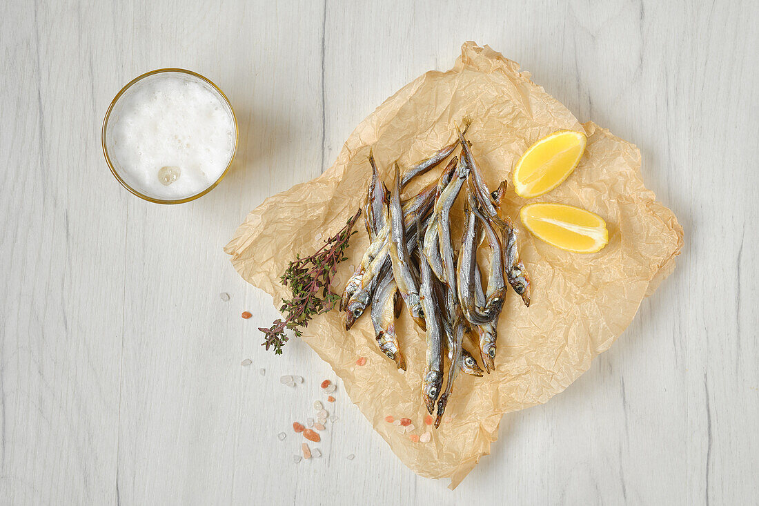 Smoked smelts with lemon wedges and spices