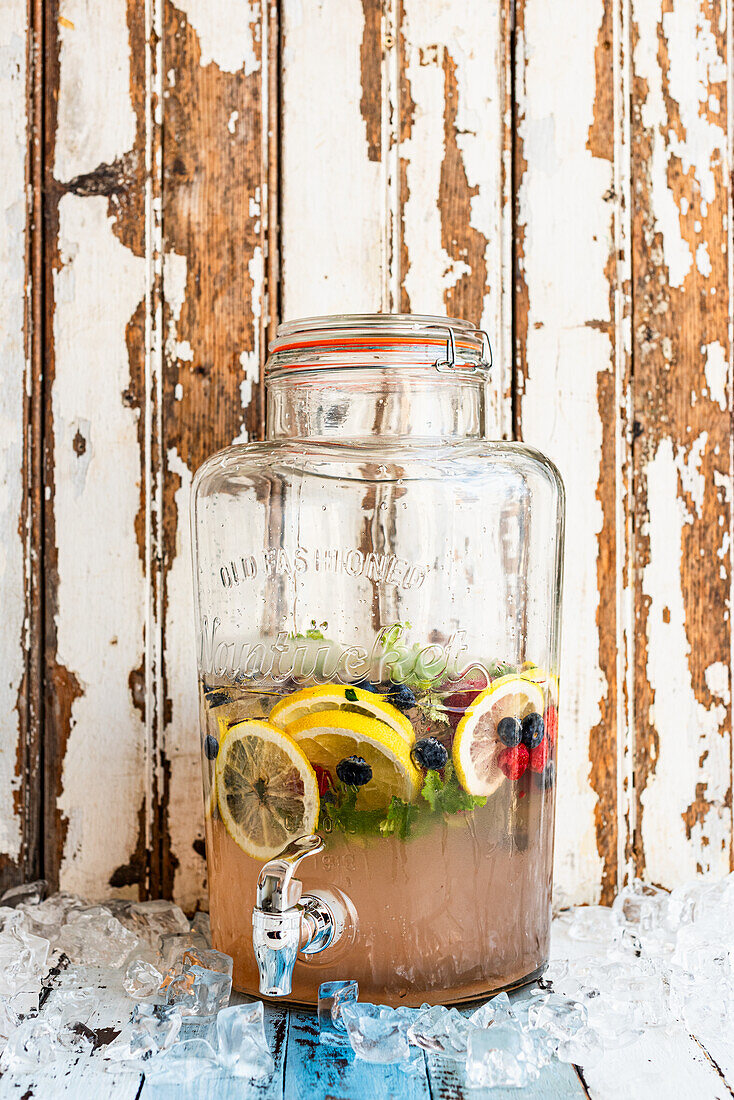 Summer drink with rose geraniums, lemons and berries