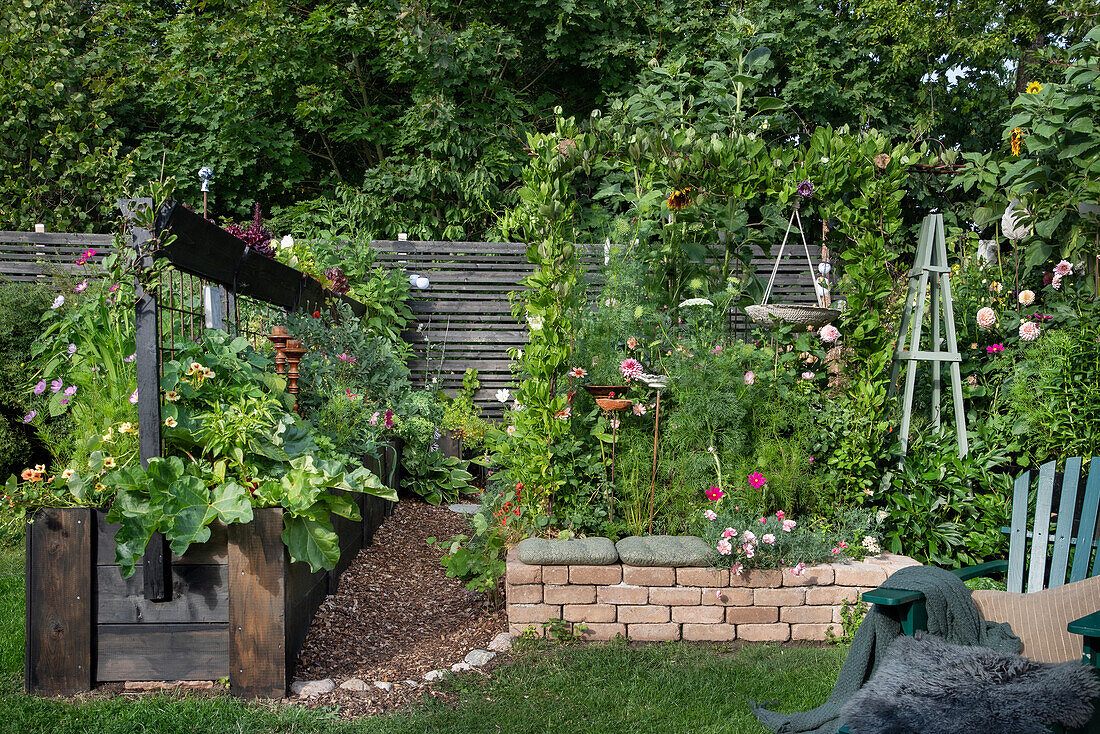 Lush garden with flower beds and raised beds in summer