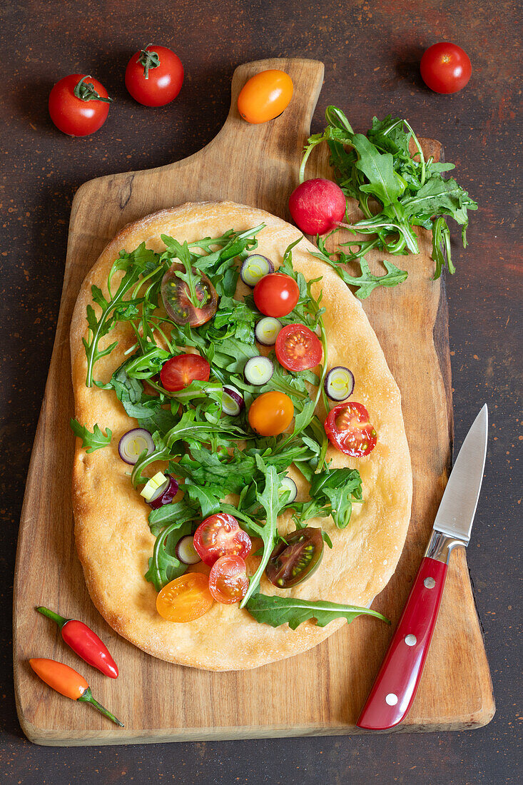 Pinsa Romana mit Rucola, Kirschtomaten und Frühlingszwiebeln