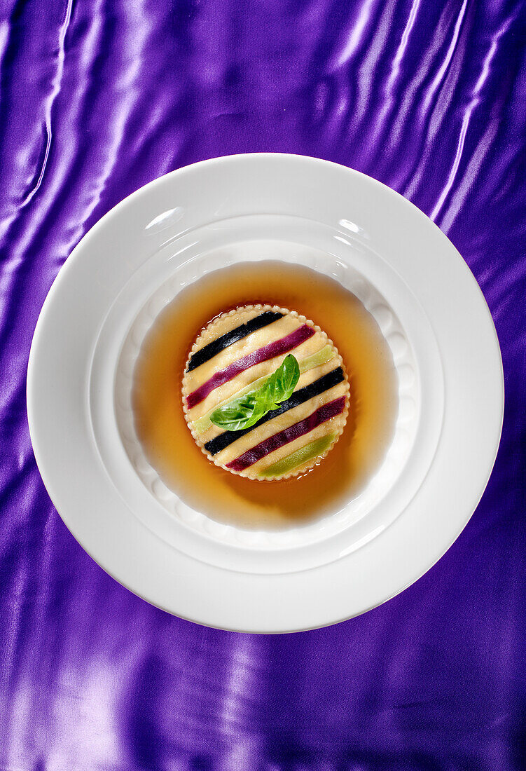 Striped giant ravioli in broth