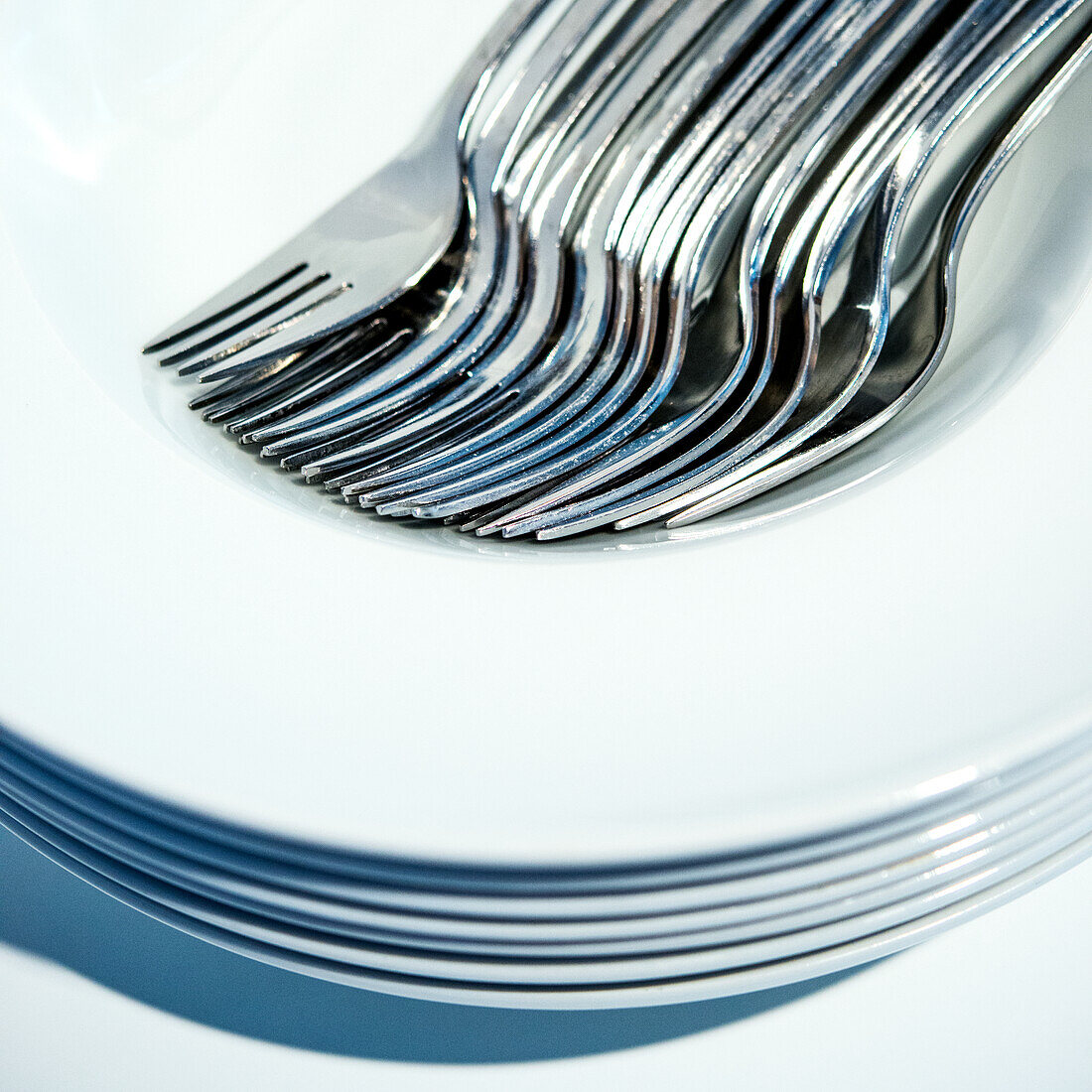 Forks placed one inside the other on a stack of plates