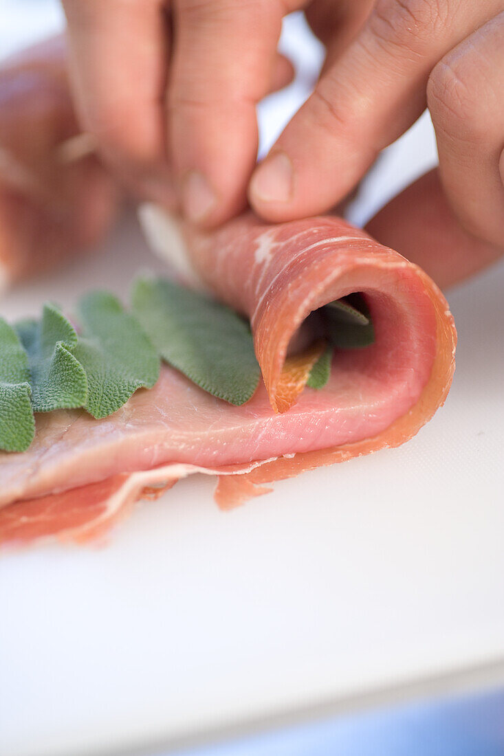 Kalbfleisch mit Salbei und Schinken einrollen für Saltimbocca-Röllchen