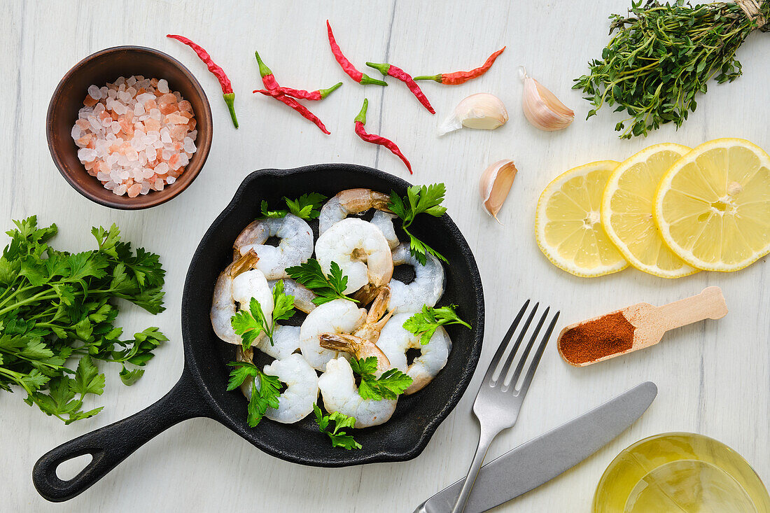 Raw prawns in pans with spices and herbs