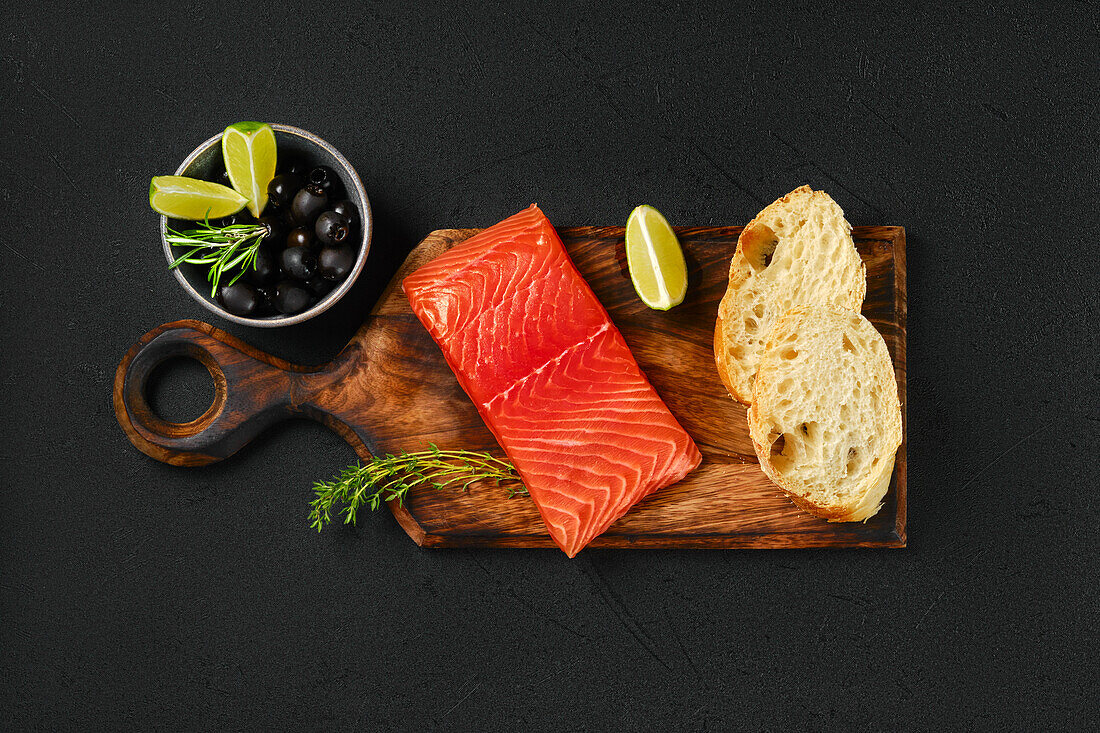 Raw salmon fillet with ciabatta and olives