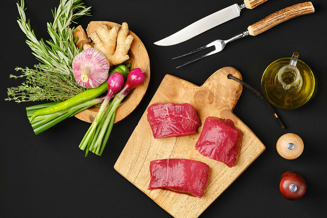 Raw beef steaks with herbs and oil