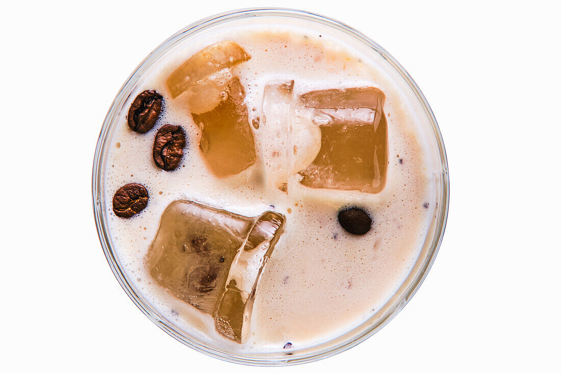 White Russian cocktail with ice cubes and coffee beans