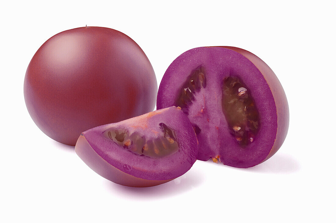 Whole and sliced purple tomatoes