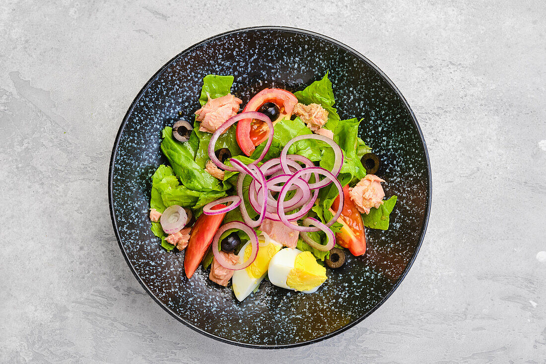 Salat mit Lachs, Tomate, Ei und roten Zwiebeln