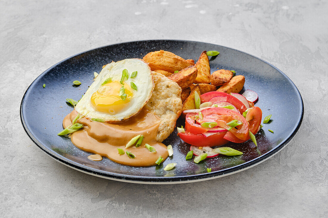 Pork steak with fried potatoes, fried egg and salad