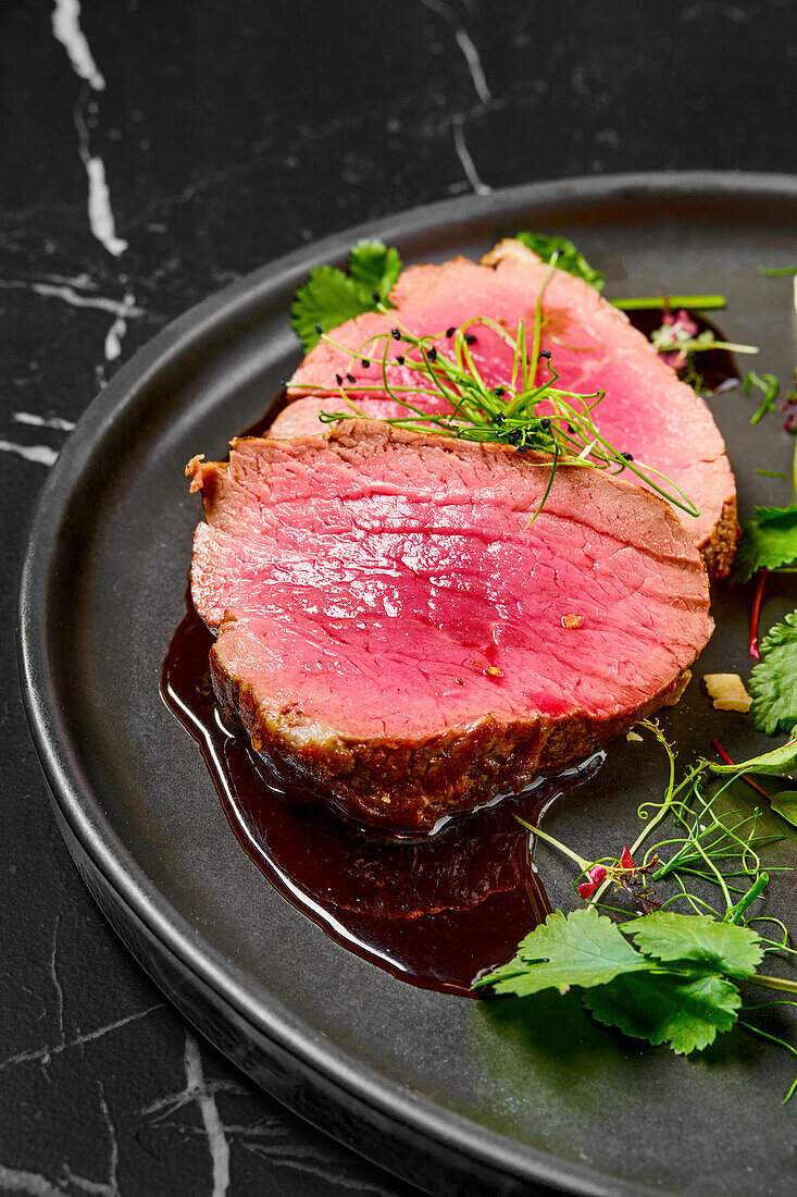 Medium-rare gegrilltes Rinderfilet mit Kräutern