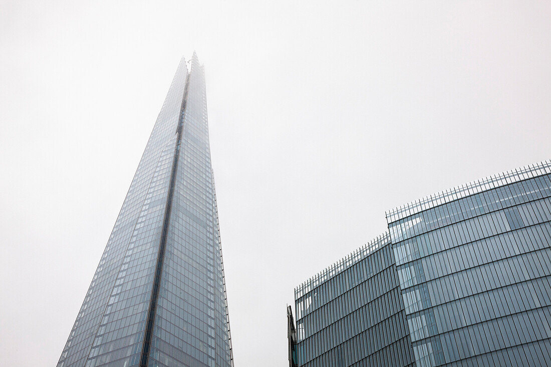 Low angle view of The Shard office building on grey day, London, England, UK