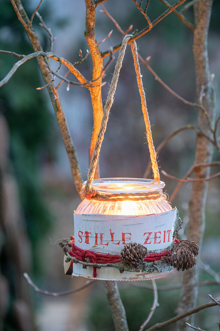 Windlicht mit Aufschrift 'Stille Zeit' im Garten an Baum hängend, Weihnachtsdekoration