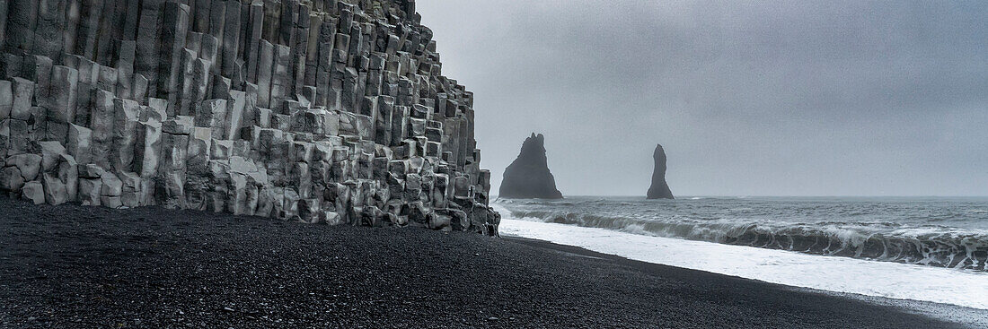 Iceland. Columnar basalt cliffs and sea stacks of Reynisfjara, Ring Road.