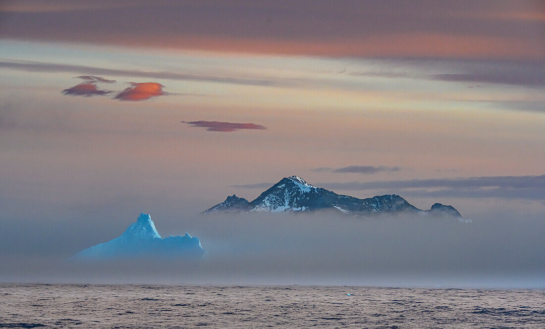 Südgeorgien Insel. Cooper Island und Blauer Eisberg ragen aus dem Nebel heraus.