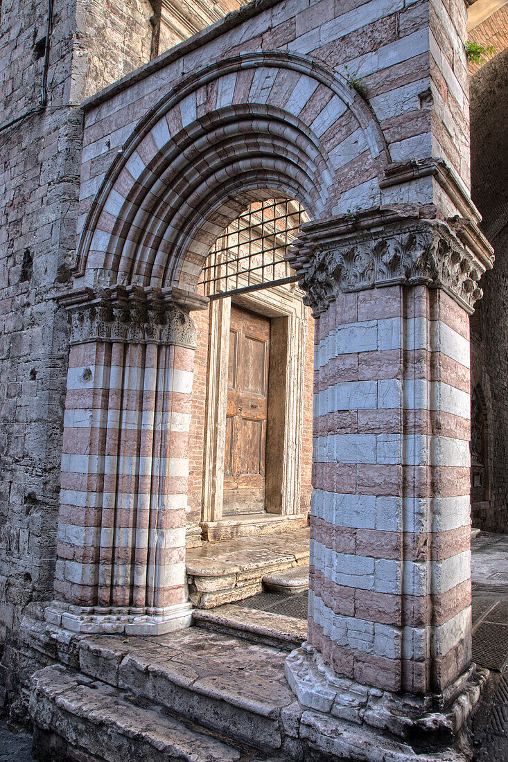 Italien, Umbrien, Perugia. Gestreifter Torbogen in der Nähe der Kathedrale San Lorenzo auf der Piazza IV Novembre.