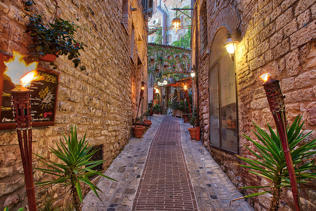 Italy, Umbria. Street lined with flower pots in the town of Assisi.