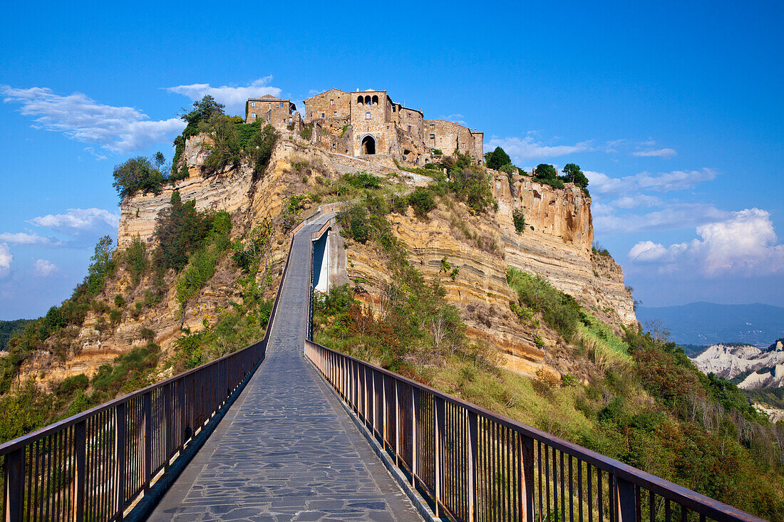 Italy, Tuscany. Evening view of Civita di Bagnoregio and the long bridge leading to town.