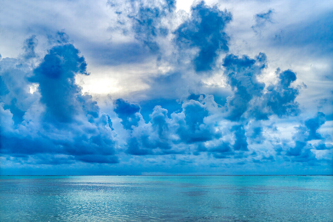 Wolkenlandschaft, Moorea, Tahiti, Französisch-Polynesien. Verschiedene Blautöne im Wasser der Lagune und der Korallenriffe