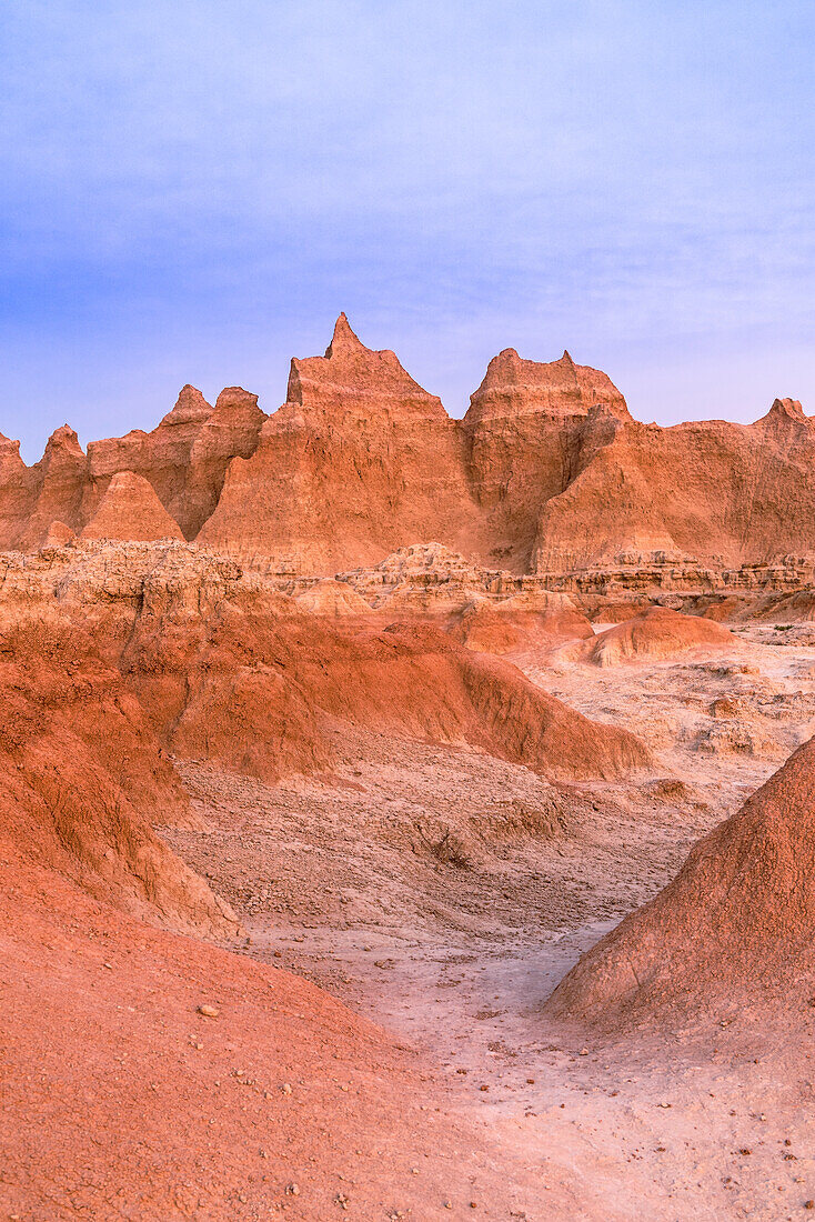 Die Farben des Sonnenuntergangs spiegeln sich in den Klippen und Gipfeln der Hoodoos im Badlands National Park.