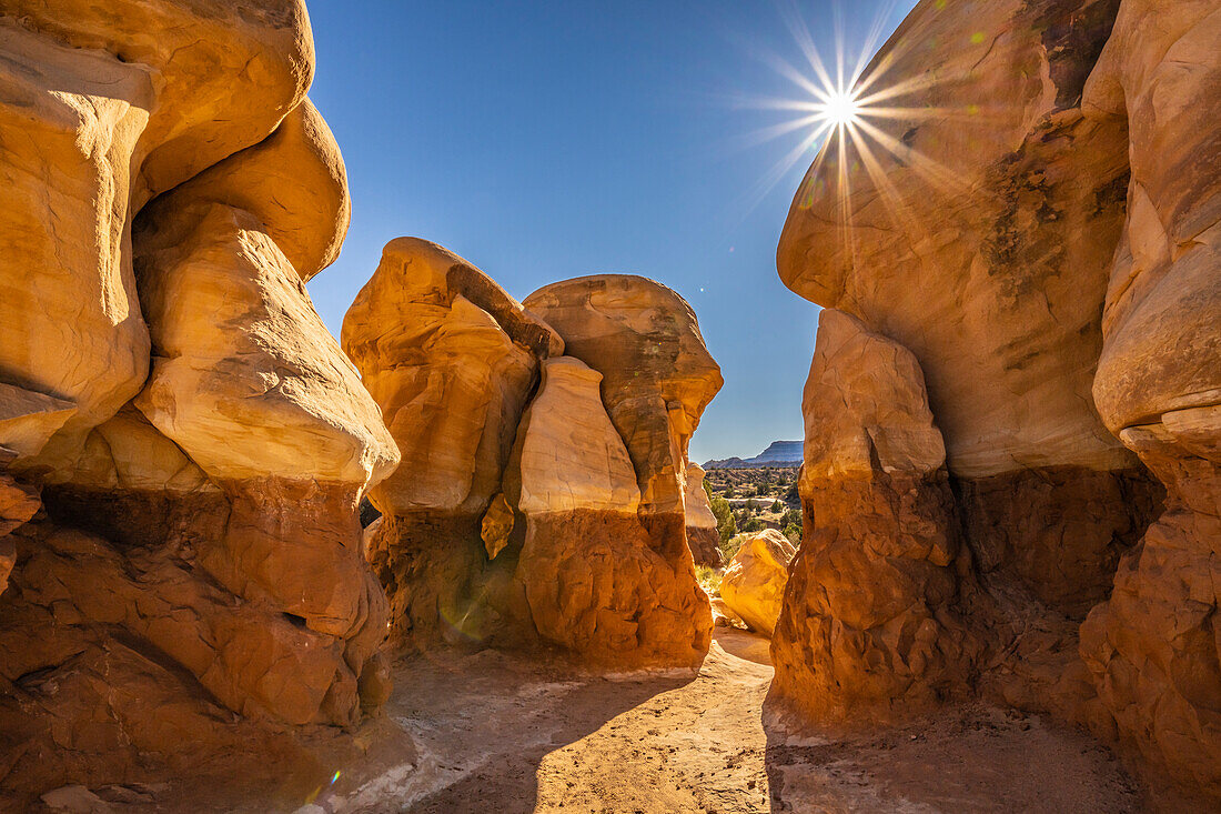 USA, Utah, Devil's Garden Outstanding Natural Area. Sonnenstarburst auf Hoodoo-Felsformationen.