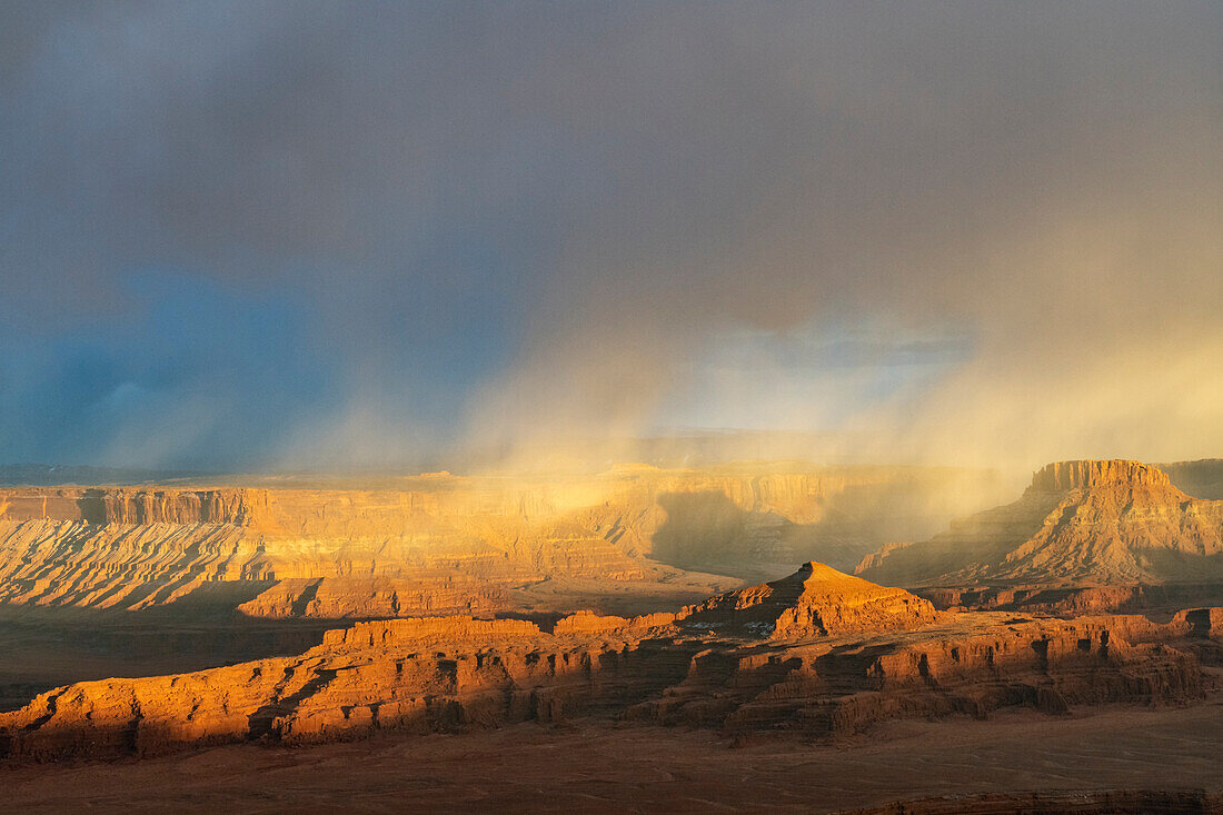 USA, Utah. Storm clouds and breakthrough sunset light on the mesas at Dead Horse Point Overlook, Dead Horse Point State Park.