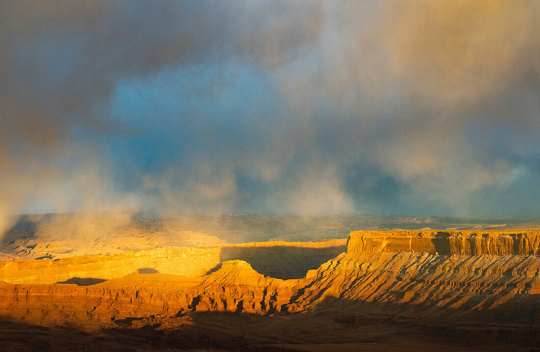 USA, Utah. Gewitterwolken und durchbrechendes Sonnenuntergangslicht auf den Tafelbergen am Dead Horse Point Overlook, Dead Horse Point State Park.