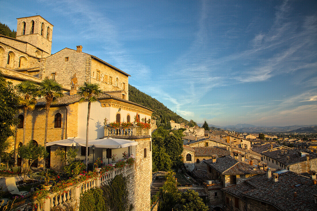 Italien, Umbrien. Abendlicht auf blumengeschmückten Gebäuden mit Blick auf die mittelalterliche Stadt Gubbio.