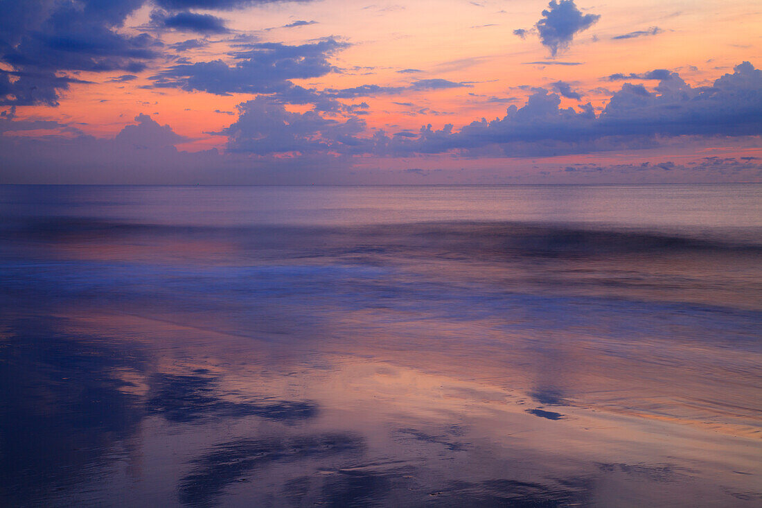 USA, Georgia, Tybee Island. Sunrise with clouds and reflections along the coast.