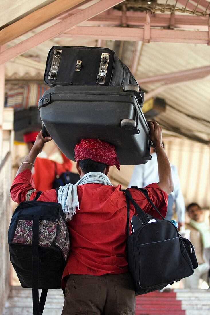 Head-loading porter carrying luggage at Jaipur Junction train station in Jaipur, capital of Rajasthan, India. March.ÃŠAsia.ÃŠ