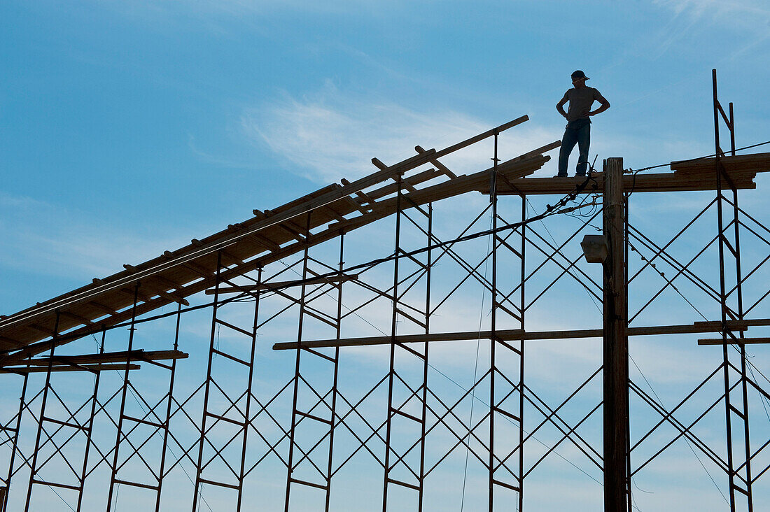 Man standing on scaffolding; Moni Chrysoskalitissas, Crete, Greece