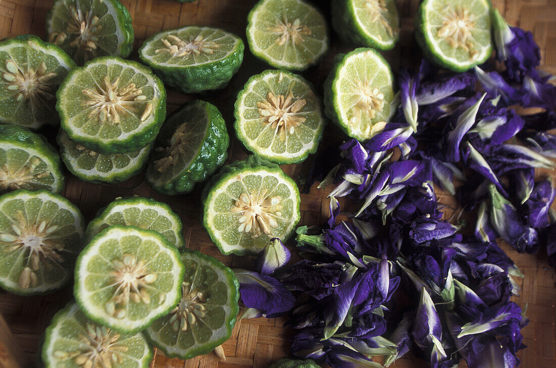 Frische Limetten und Blumen bei der Herstellung eines natürlichen Kräutershampoos, Khon Kaen, Thailand.