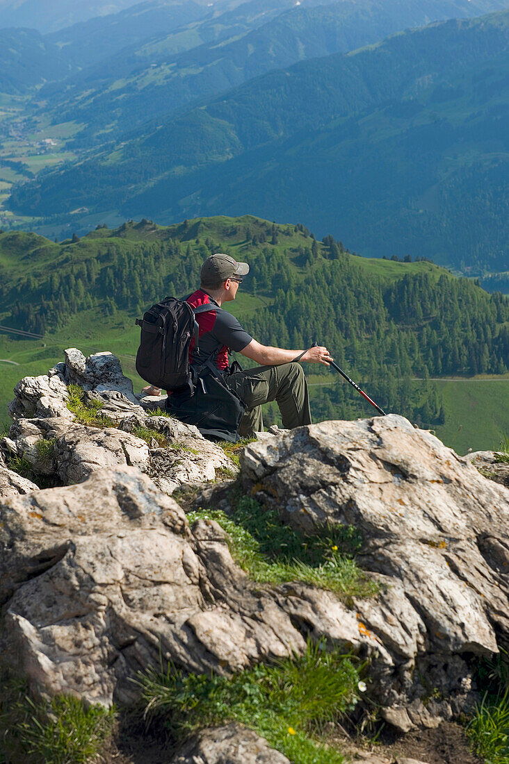 Ein männlicher Wanderer genießt den Panoramablick vom Kitzbüheler Horn. Kitzbühel, Tirol, Österreich.
