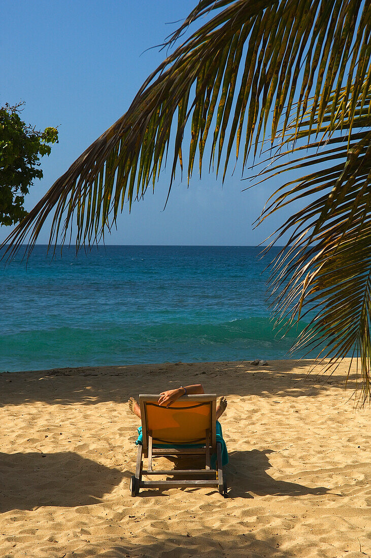 Woman Sunbathing Near Palm Trees On Magazine Beach; Carriacou Island, Grenada