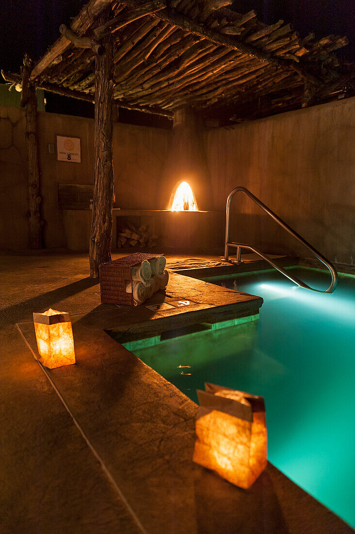 Outdoor Spa Pool bei Nacht mit einem Kiva Feuer in Ojo Caliente Mineral Springs ist ein Resort und Spa im nördlichen New Mexico in der Nähe von Santa Fe