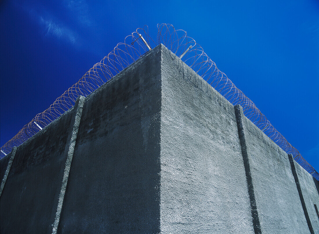 Detail der Hauptmauer mit Stacheldraht des Gefängnisses auf Robben Island, Kapstadt, Südafrika.