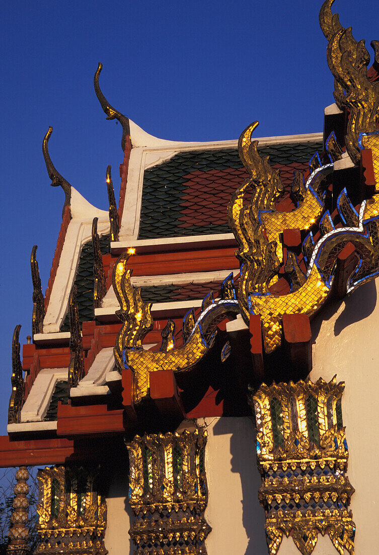 Red and gold ornate architectural detail of a pagoda and a blue sky