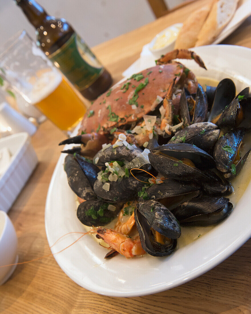 Vereinigtes Königreich, England, Cornwall, Muscheln und Tigergarnelen in Weißwein-Sahne-Sauce mit Salat und Brot; Falmouth, Ganze Krabbe, Frische Meeresfrüchte aus Cornwall